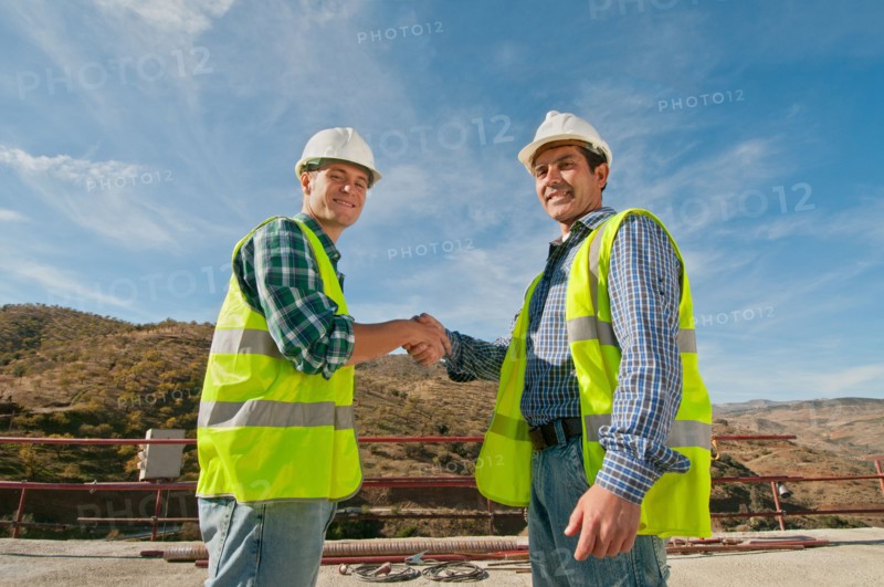 Two construction engineers shaking hands