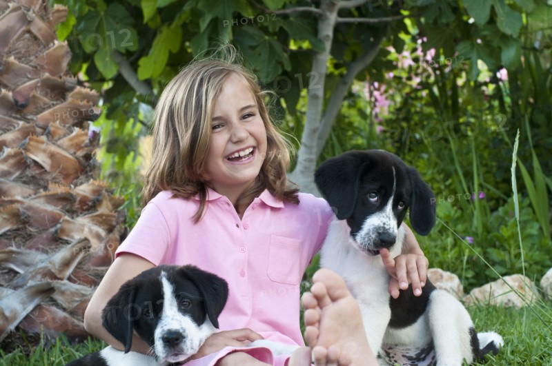 young girl with dogs in garden