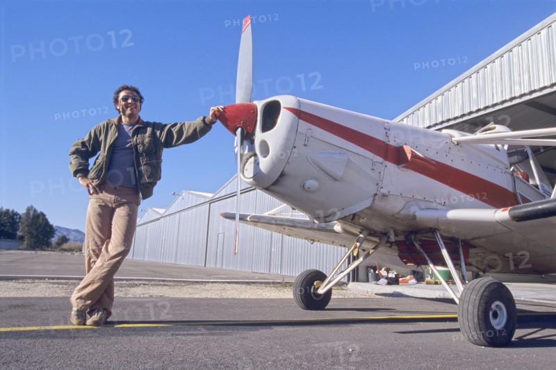 Smiling Man Standing Next to a Monoplane
