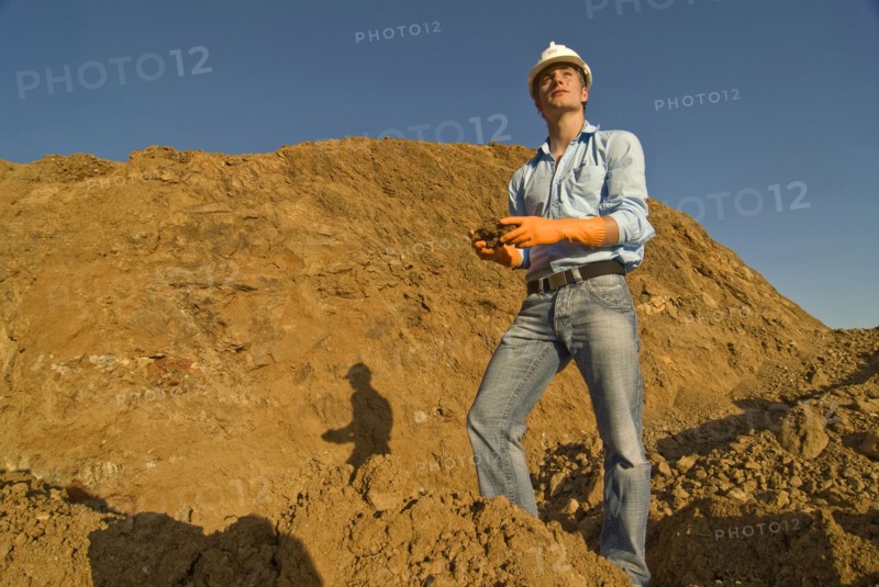 Young engineer checking soil samples on construction site