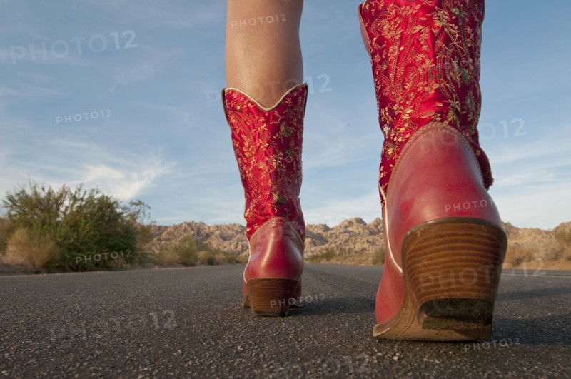 Woman in red boots walking to horizon