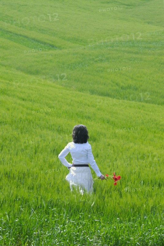 Woman standing in field rear view