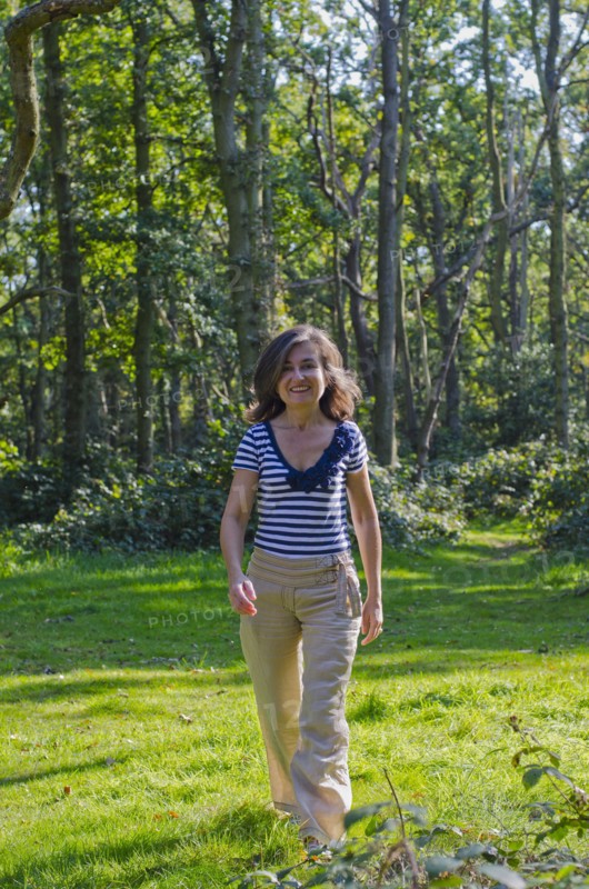 woman walking across clearing in forest