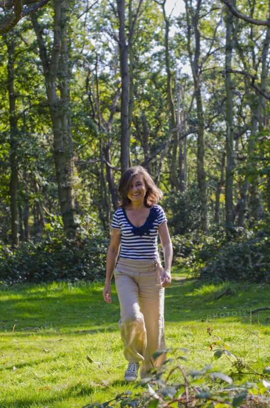 woman walking across clearing in forest