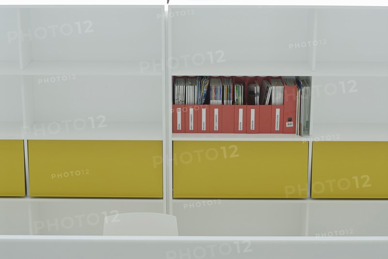Magazines on coloured shelf in office building