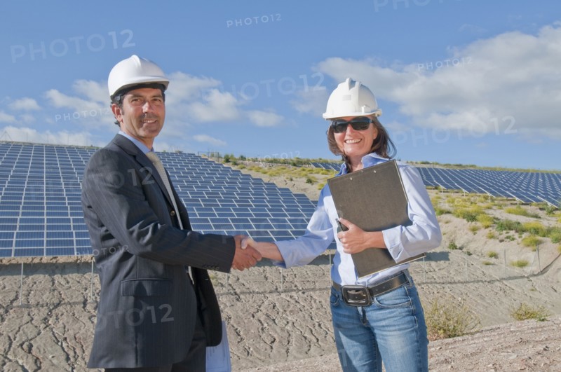 businessman shaking engineer's hand in solar plant