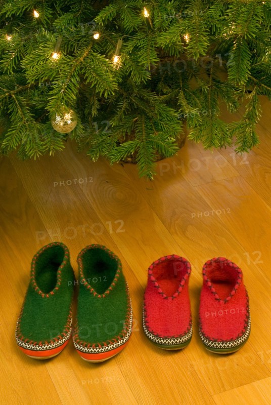 Two pairs of slippers under Christmas tree