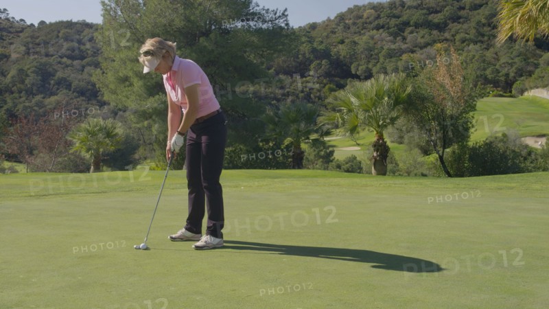 Caucasian woman putting on golf course