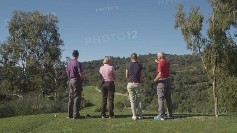 Caucasian friends examining fairway on golf course