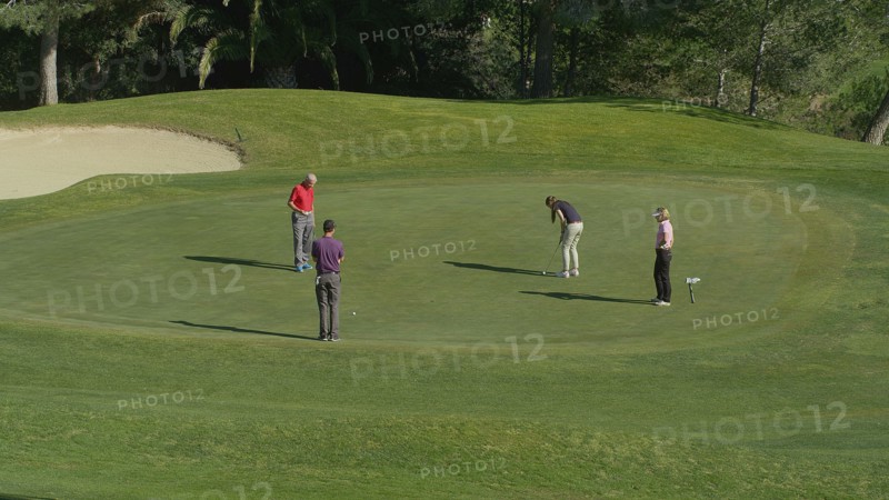Caucasian friends putting on golf course