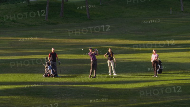 Caucasian friends playing golf on course