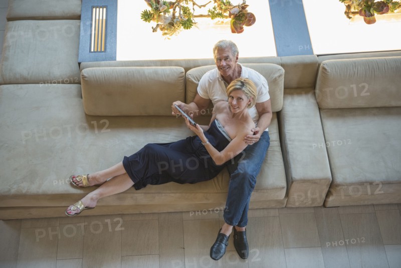 High angle view of Caucasian couple using digital tablet in hotel lobby