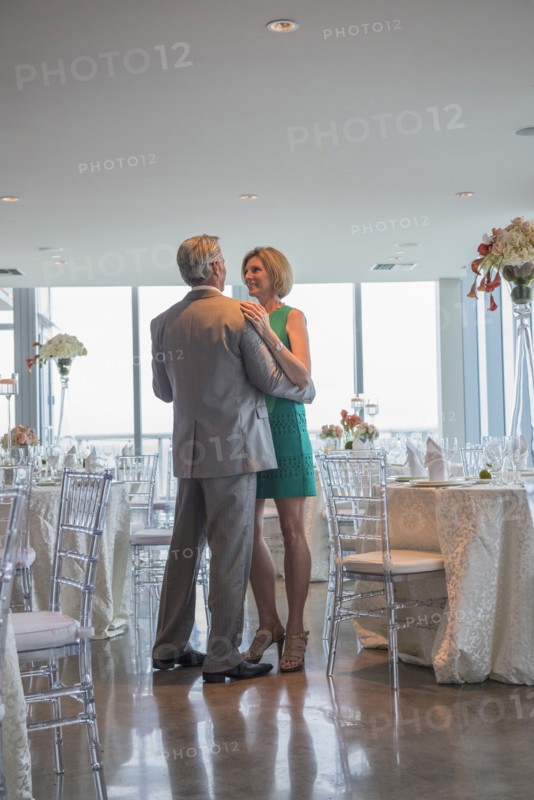 Caucasian couple dancing in empty restaurant