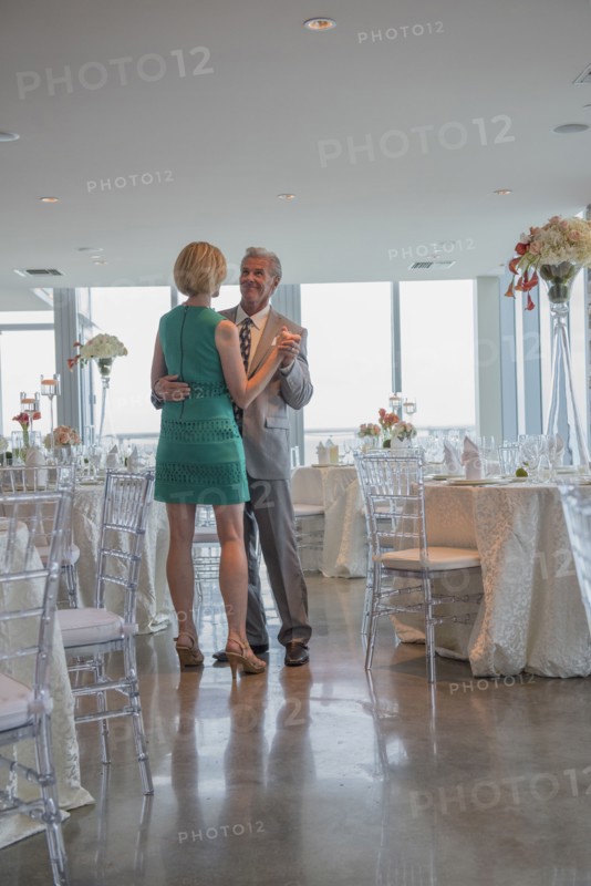 Caucasian couple dancing in empty restaurant