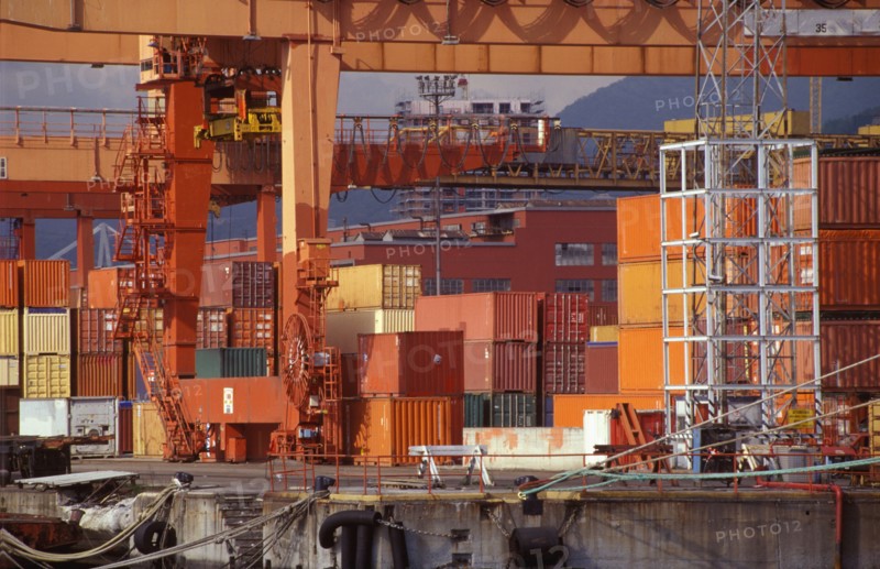 Shipping containers and cranes in industrial shipyard