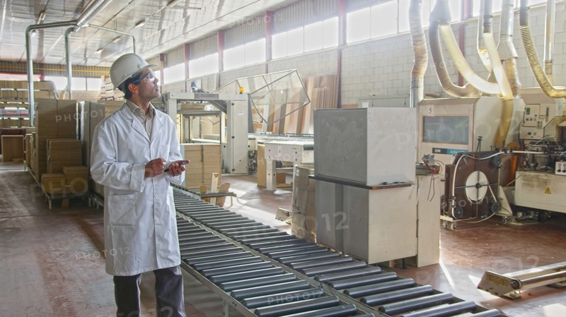 Hispanic worker checking production line in factory