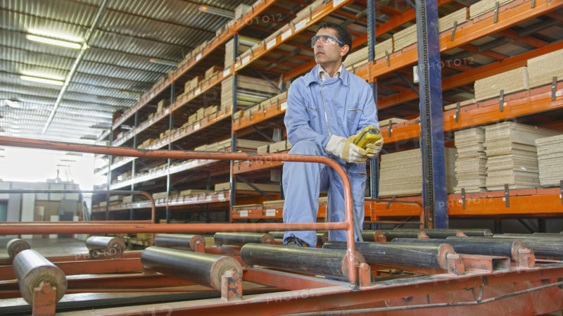 Hispanic worker checking inventory in factory