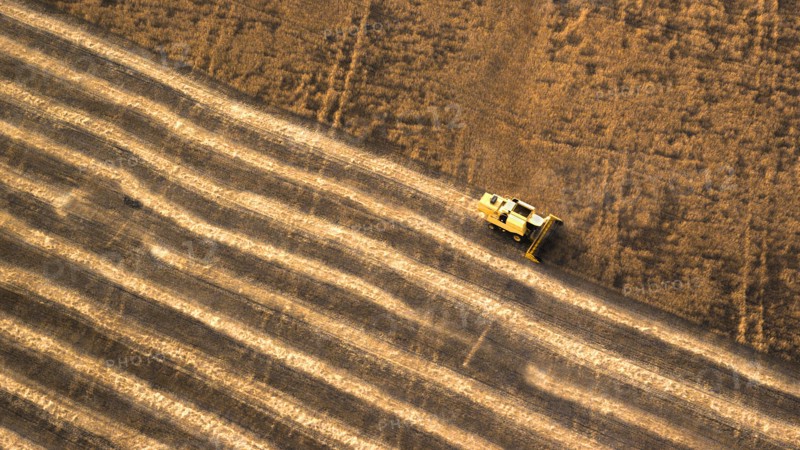 Aerial view of combine harvester in farm field