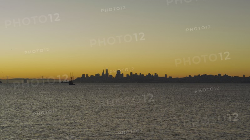 Silhouette of urban waterfront skyline at sunset