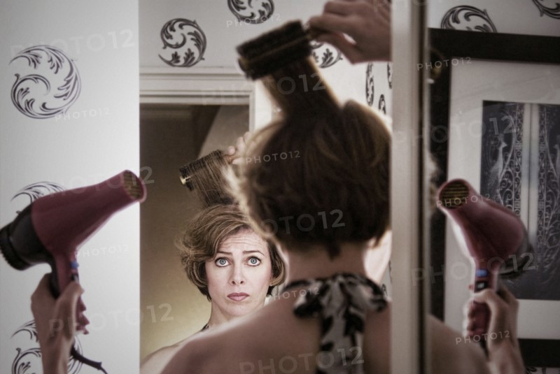 Overwhelmed Caucasian woman styling her hair