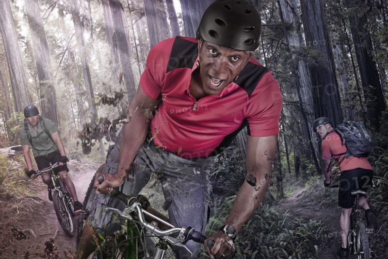 Caucasian man riding mountain bike in forest