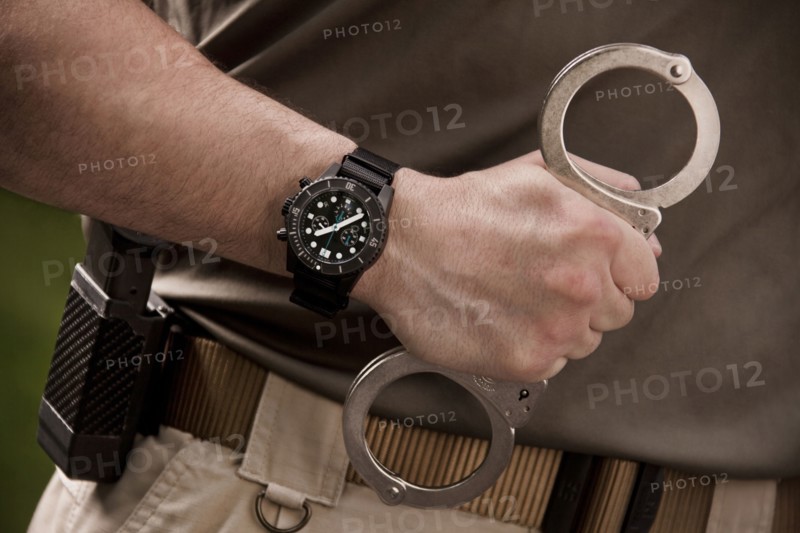 Close up of police officer holding handcuffs