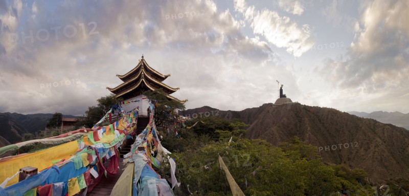 Panoramic view of prayer flags and traditional building on mountain