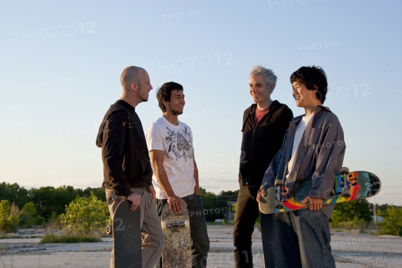 Men holding skateboards in parking lot