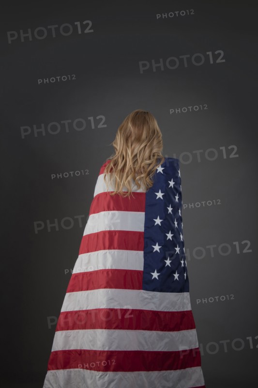 Mixed race woman wrapped in American flag