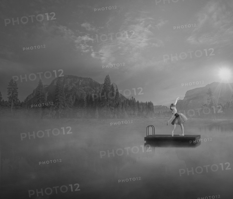 Caucasian ballet dancer on floating dock in foggy lake