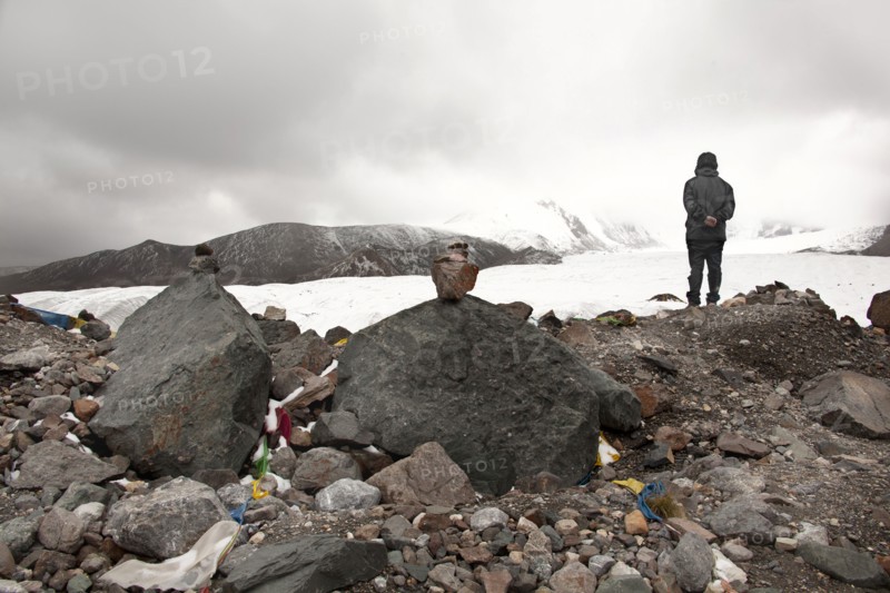 Pensive man standing on rocks in winter landscape
