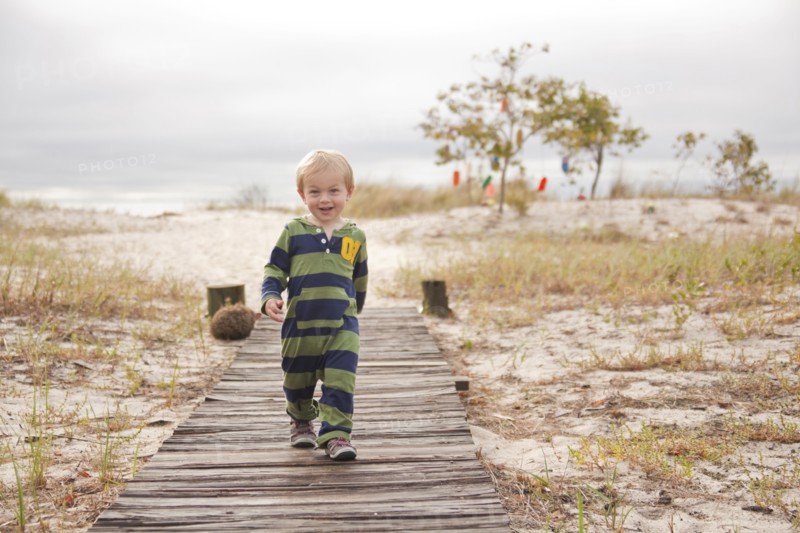 Caucasian boy walking on boardwalk at beach