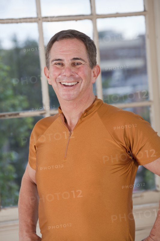 Smiling Caucasian mean standing near window