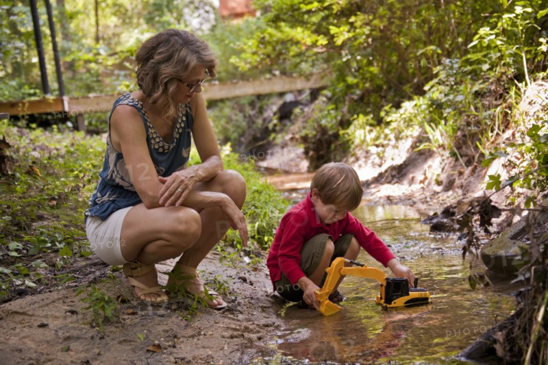 Caucasian mother watching son playing with construction toys in river