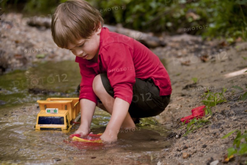 Caucasian boy playing with construction toys in river