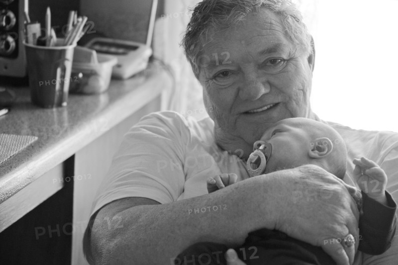 Caucasian grandfather holding baby grandson