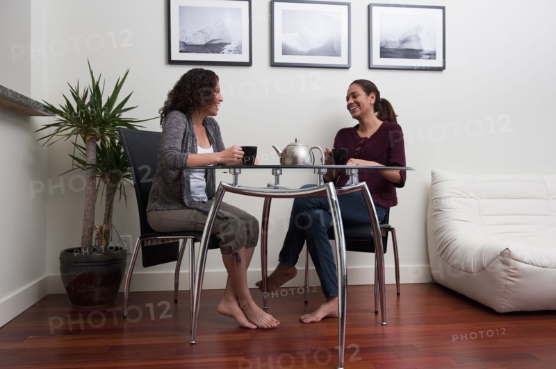 Hispanic women talking and drinking coffee