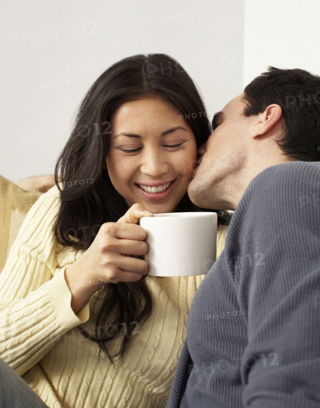 Husband kissing wife drinking coffee
