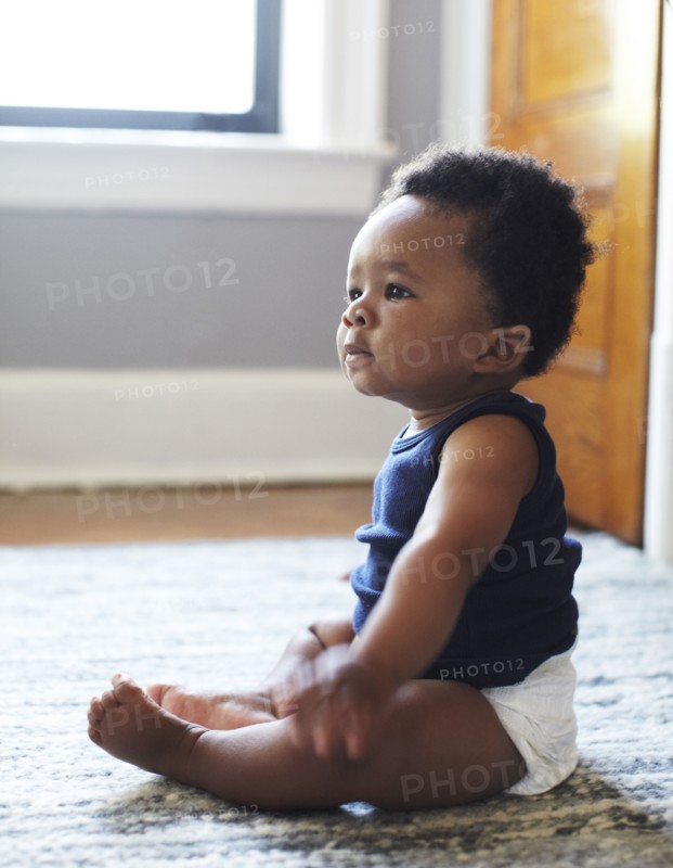 African American baby sitting on floor