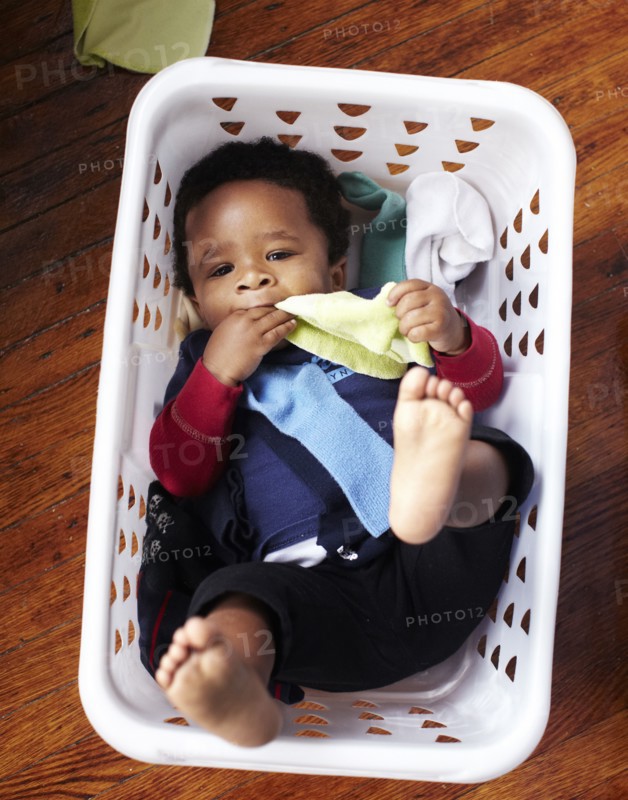 African American baby laying in laundry basket