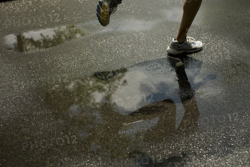 Woman running through puddle