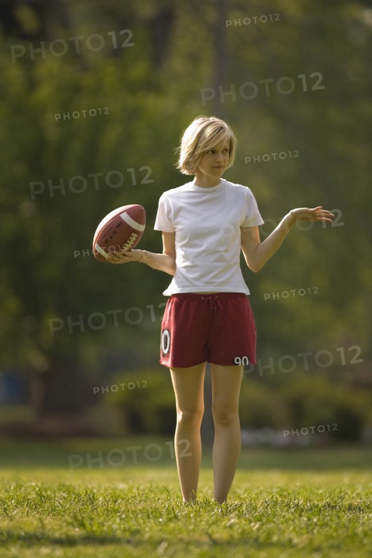 Uncertain woman holding football