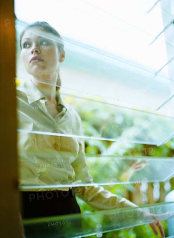 Woman behind window in greenhouse