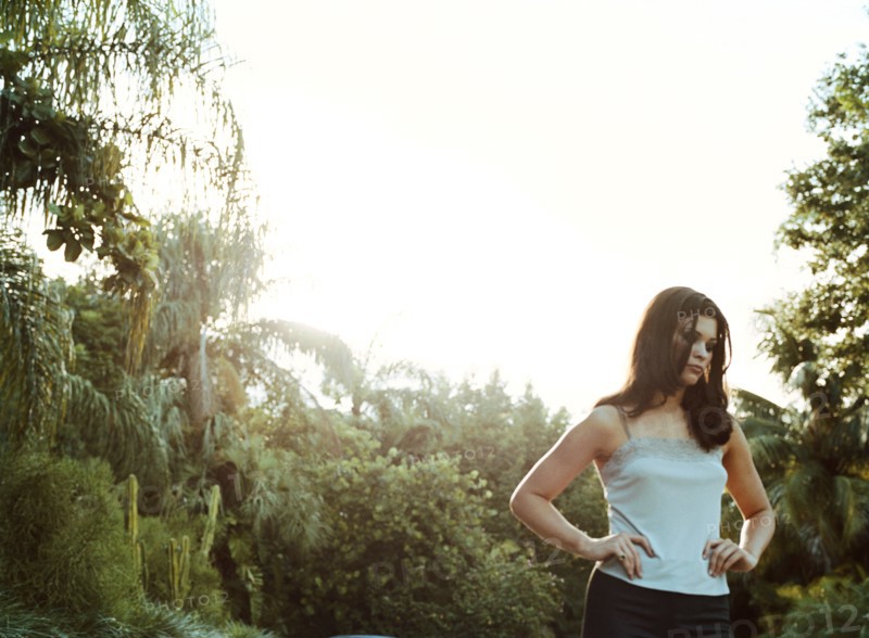 Woman standing outdoors with hands on hips
