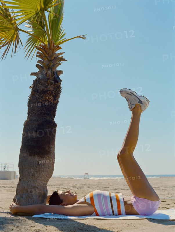 Mixed race woman exercising on beach