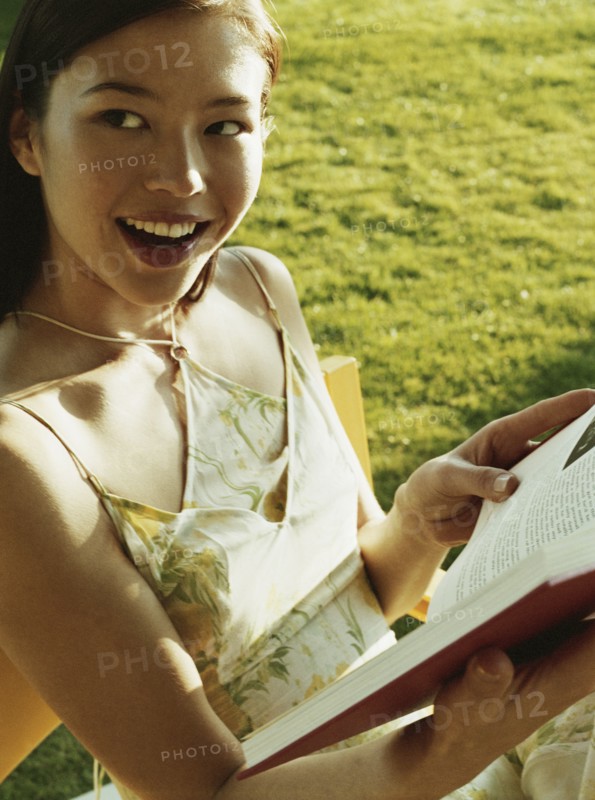 Woman reading book in chair