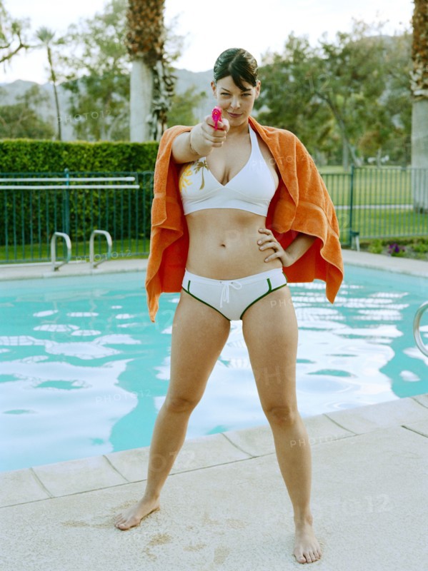 Woman in bikini aiming water gun