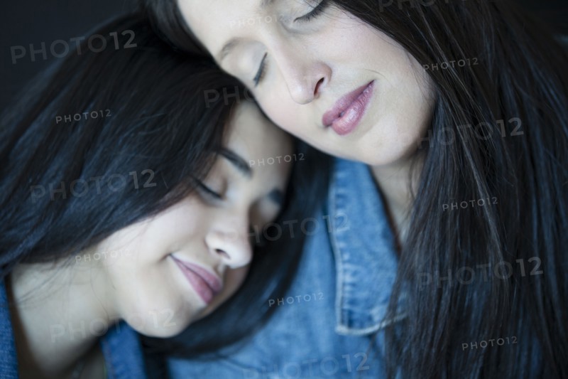 Close up of Hispanic mother and daughter hugging