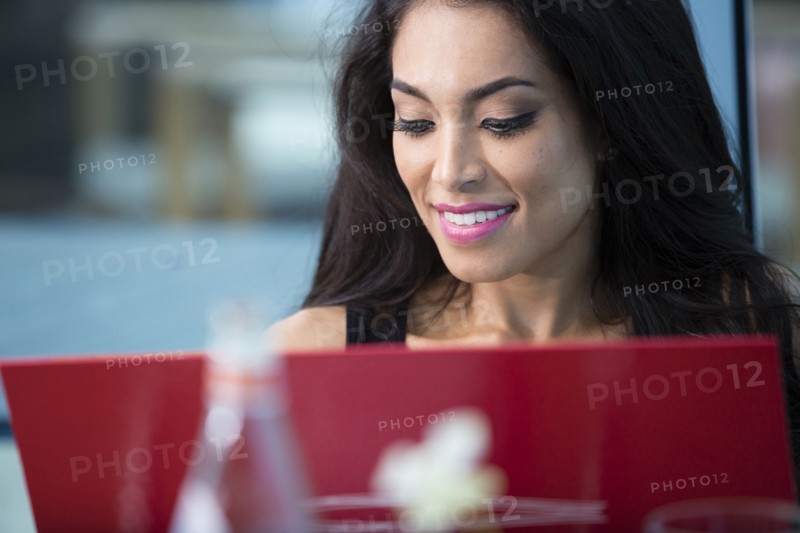 Hispanic woman using laptop in cafe
