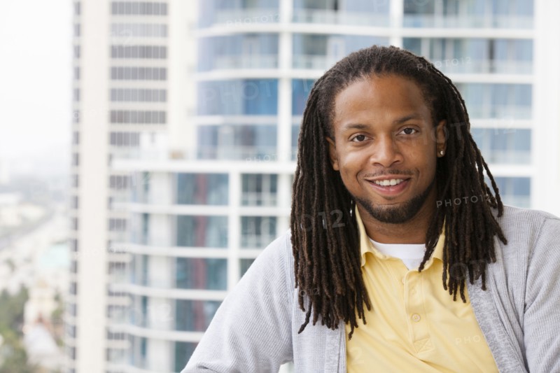 African American man smiling on urban balcony